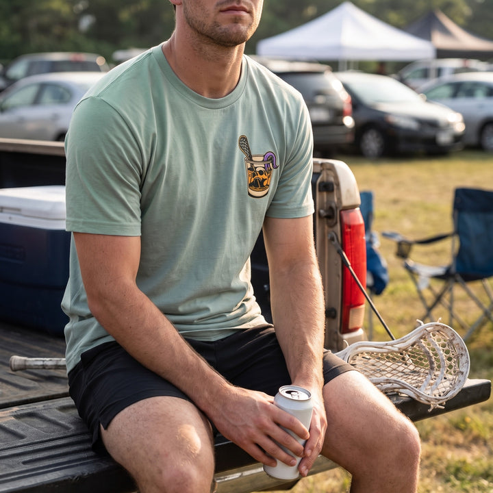 Rip &amp; Sip Tee in seafoam, front chest print worn sitting on a pickup tailgate