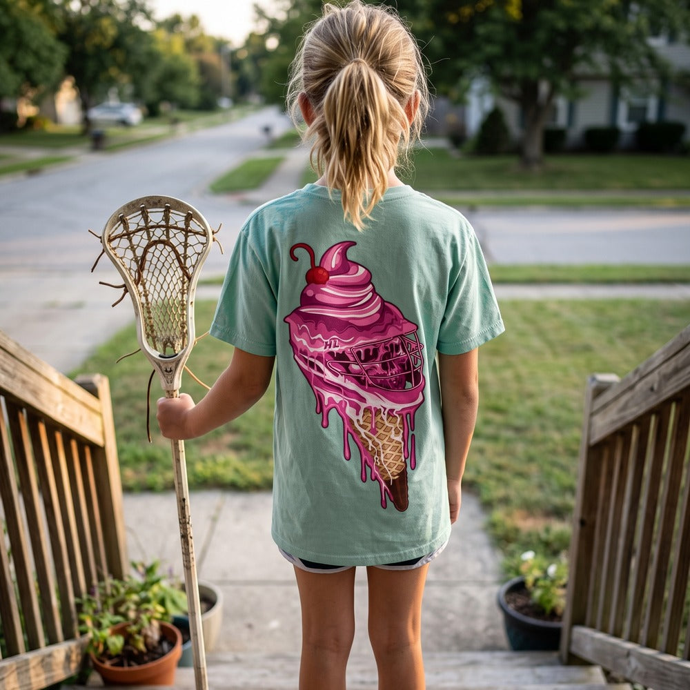 Youth Sideline Scoop Tee in seafoam worn by a girl on a front porch, back view showing the pink ice cream cone lacrosse helmet print